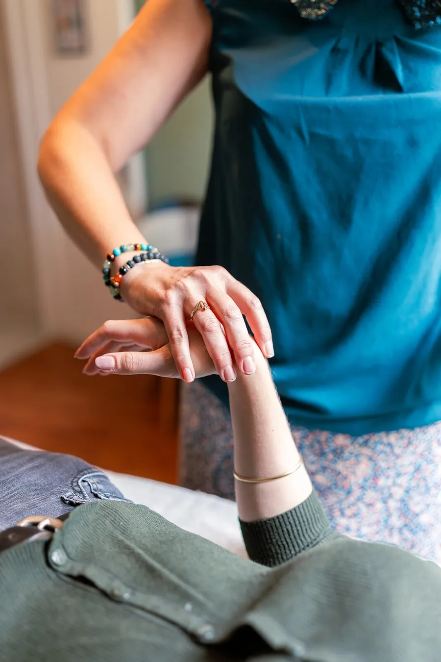 Test musculaire : Émilie Ravoire appuie doucement sur l'avant-bras tendu d'une consultante